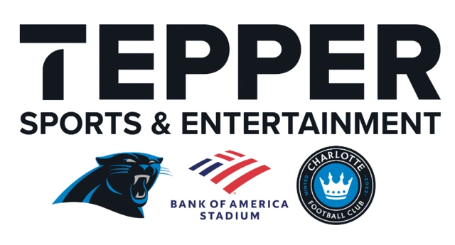 nascar pit crew standing around yellow race car